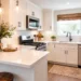 Modern small kitchen layout with white cabinets, quartz countertops, stainless steel appliances, and breakfast bar in a Katy, TX home.